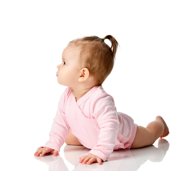Niño de 8 meses bebé niña pequeña acostada en camisa rosa mirando esquina aislada en un blanco
 - Foto, Imagen