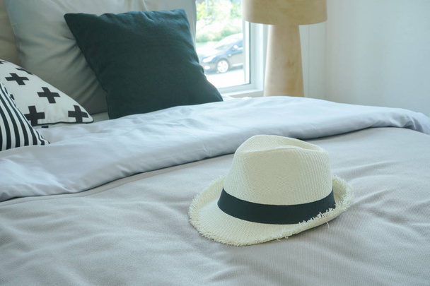 Stylish bedroom interior with hat at the center of bed - Photo, Image