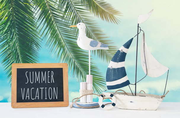 nautical concept with white decorative seagull bird, blackboard and boat over tropical sea landscape background. - Foto, imagen