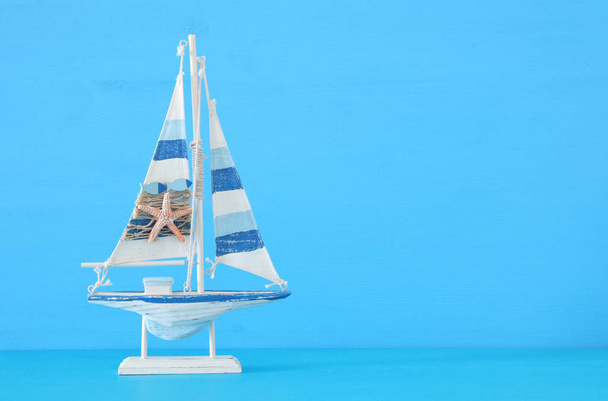 морская концепция с парусной лодкой на синем фоне
. - Фото, изображение