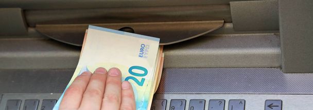 retira dinero de un cajero automático con moneda en euros
 - Foto, imagen