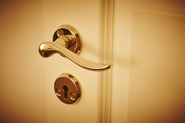 Metallic classic door knob on a white door. Open, closed - Фото, изображение