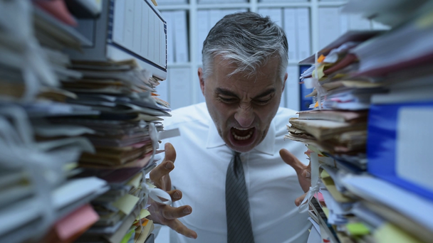 Καταπονημένος επιχειρηματίας που εργάζεται στο γραφείο και κάνει υπολογισμούς, το γραφείο του είναι καλυμμένο με χαρτιά, να είναι θυμωμένος και ουρλιάζοντας - Πλάνα, βίντεο