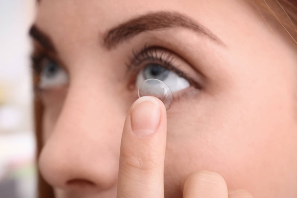 Young woman putting contact lens in her eye, closeup - Photo, image