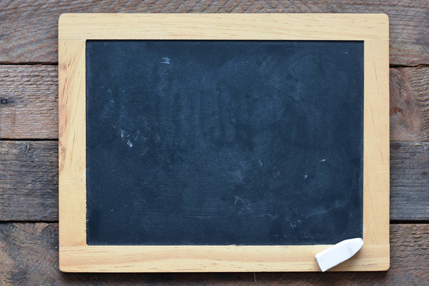 Closeup of blackboard and piece of chalk  - Photo, Image