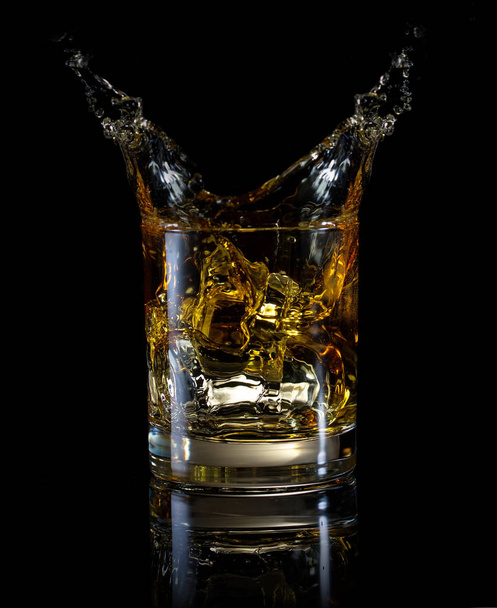Een glas whiskey en splash - Foto, afbeelding
