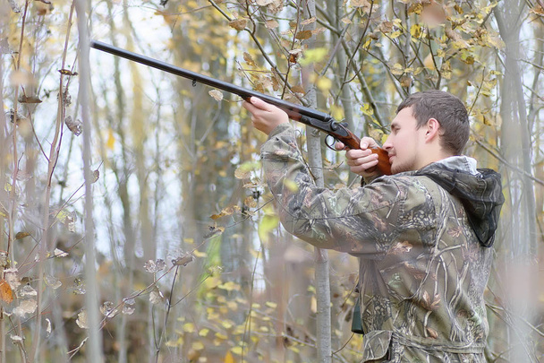 Homem em camuflagem e com armas em um cinto florestal em um hun primavera
 - Foto, Imagem