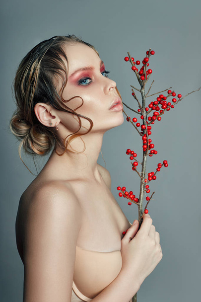 Tree Branch with red berries in hand Woman blonde wet hair brigh - Fotó, kép