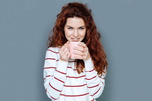 Delighted red haired woman enjoying her drink - Fotoğraf, Görsel