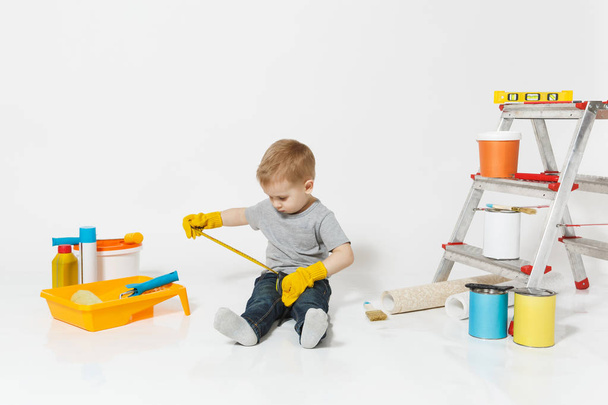 Aranyos kisfiú eszközök felújítás apartman szoba elszigetelt fehér háttér sárga kesztyű. Háttérkép, tartozékok ragasztás, festés eszközök. Home javítás. Szülői, gyermekkor fogalma. - Fotó, kép