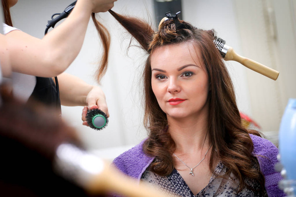 Menina no salão de beleza, enquanto um cabeleireiro secar o cabelo
 - Foto, Imagem