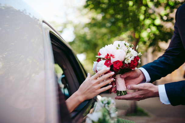 Bräutigam schenkt Braut einen Blumenstrauß - Foto, Bild