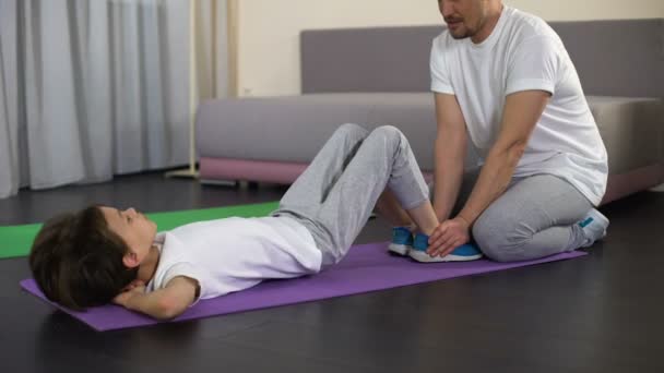 Dad training male kid to do crunches at home, active leisure, healthy lifestyle - Filmmaterial, Video