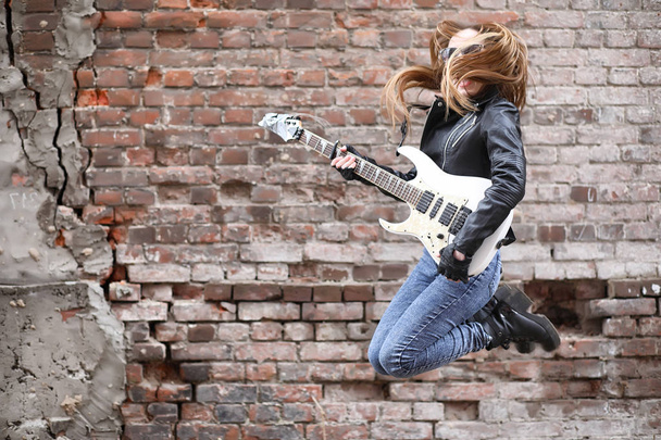  Una musicista rock in giacca di pelle con chitarra
  - Foto, immagini