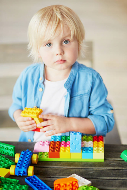 Adorable little boy playing with colorful plastic construction blocks at home, in kindergaten or preschool. Creative games for kids - Fotoğraf, Görsel