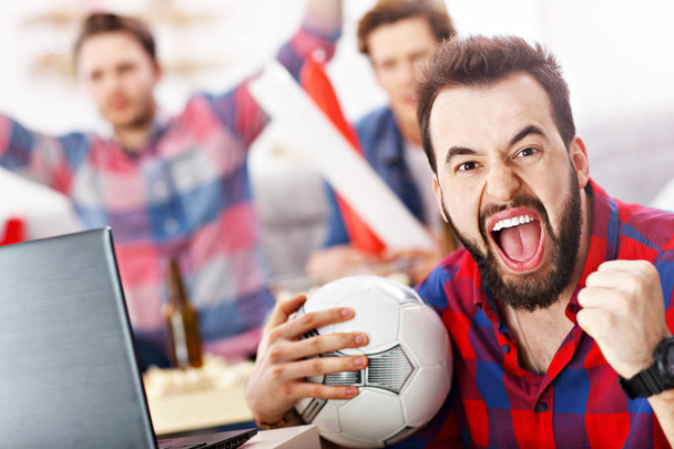 Happy male friends cheering and watching sports on tv - Photo, Image