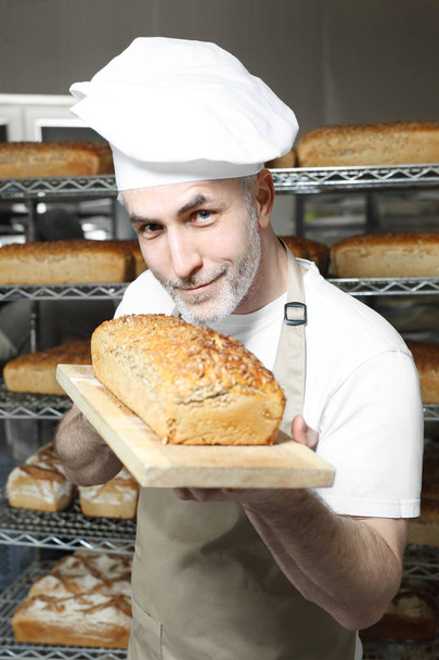 Baker. The process of baking bread - Valokuva, kuva
