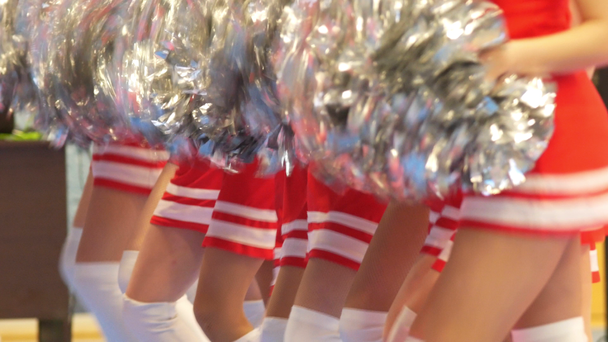Girls cheerleaders in a red dresses dancing with pompoms - Footage, Video