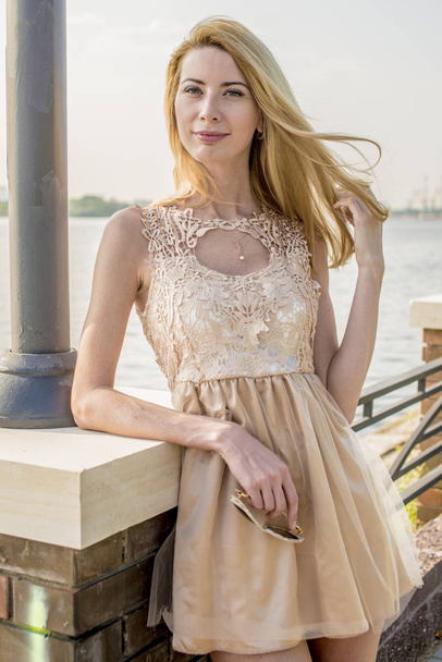 Young beautiful blonde woman in a beautiful dress in a summer park - Zdjęcie, obraz