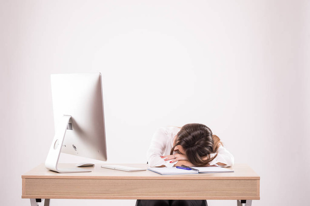 . κουρασμένος νεαρή γυναίκα στον ύπνο, να κάθεται στο γραφείο σας που απομονώνονται σε λευκό φόντο - Φωτογραφία, εικόνα