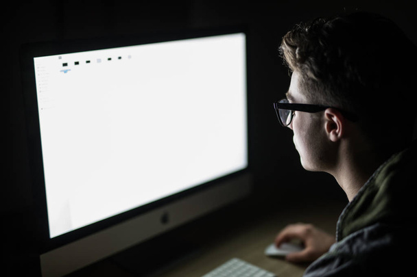 Portre genç adam oturmuş ve karanlık odada boş ekran bilgisayar kullanarak. hacker ya da programcı karanlık odada. - Fotoğraf, Görsel