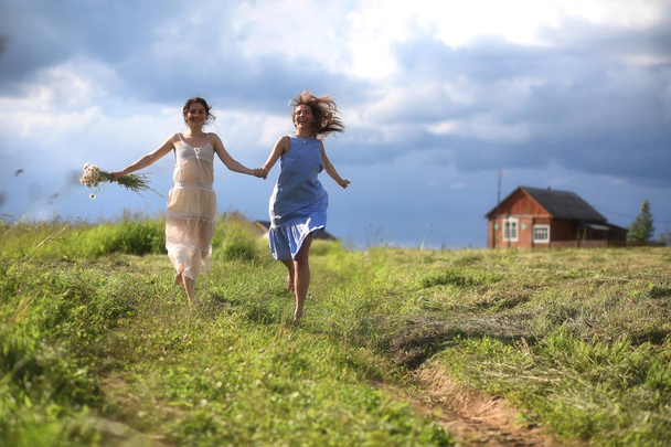 Young girls are walking in the field - Foto, Imagen