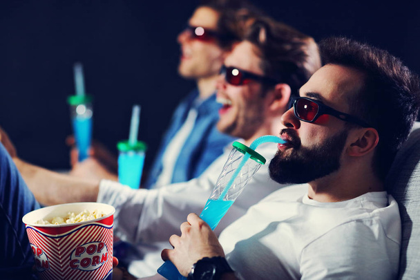Ομάδα φίλων χαρούμενος κάθεται σε κινηματογραφική ταινία ρολόι και τρώγοντας ποπ κορν - Φωτογραφία, εικόνα