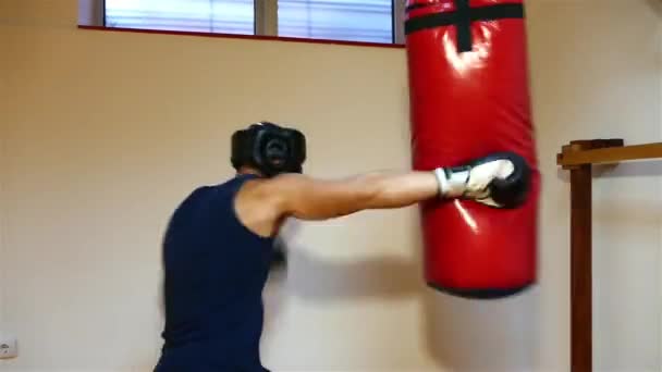 Erős fiatal ökölvívó, a boksz zsák ütő - Felvétel, videó