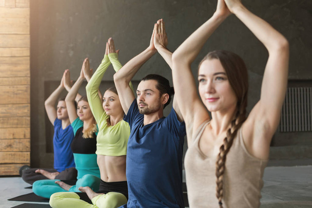 Jeunes femmes et hommes en cours de yoga, pose de méditation relaxante
 - Photo, image