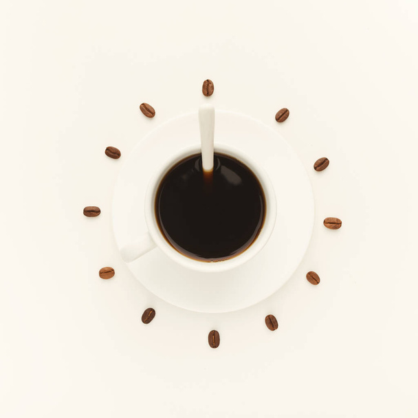 Filiżanki czarnej kawy i palonych ziaren stanowiących o na białym tle tarczy zegara - Zdjęcie, obraz