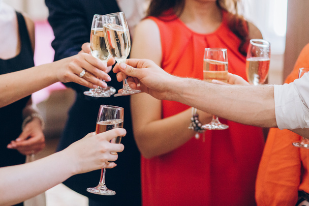 grupo de pessoas elegantes segurando copos de champanhe na recepção de casamento de luxo. pessoas mãos brindar e torcer com bebidas em eventos sociais. celebração de Natal
 - Foto, Imagem