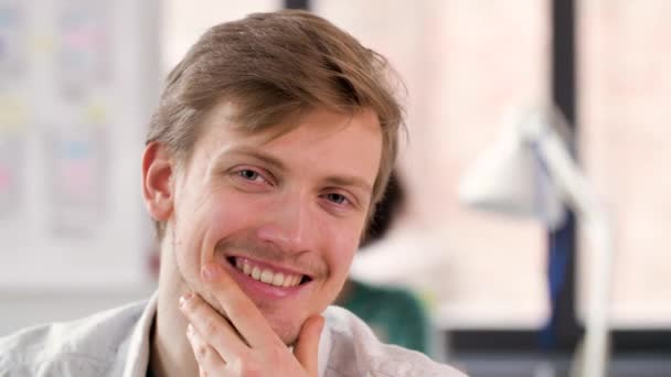 portrait of happy smiling young man at office - Záběry, video