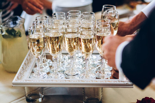 Elegante Menschen mit Champagnergläsern bei einer luxuriösen Hochzeitsfeier. Hände, die bei geselligen Anlässen mit Getränken anstoßen und jubeln. Bewirtung bei Weihnachtsfeier - Foto, Bild