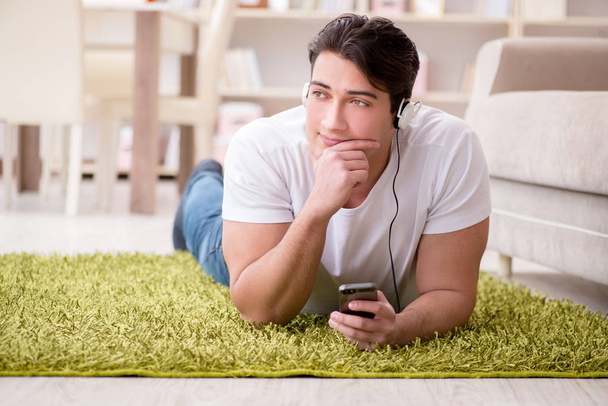 Jeune homme étudiant écoutant de la musique à la maison - Photo, image