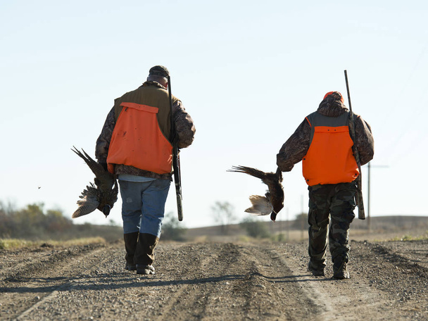 Отец и сын охотятся на фазанов осенним утром
 - Фото, изображение