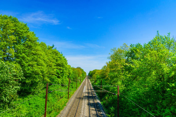 Train railroad against sunny blue sky. Landscape with railway track in countryside. - 写真・画像