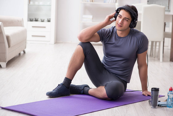 Man doing sports at home and listening to music - Foto, immagini