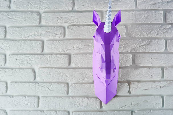 Violet unicorns head on the wall. - Foto, afbeelding