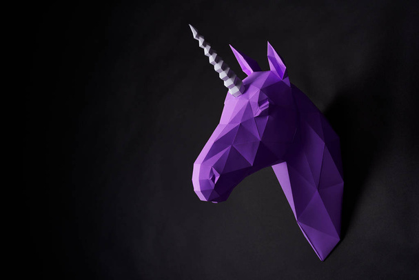 Sideview of violet shadowed unicorns head hanging on wall. - Foto, afbeelding