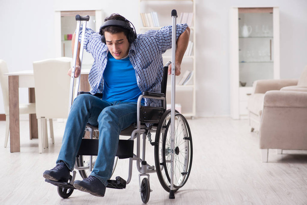 Zdravotně postižený muž poslouchá hudbu na invalidním vozíku - Fotografie, Obrázek