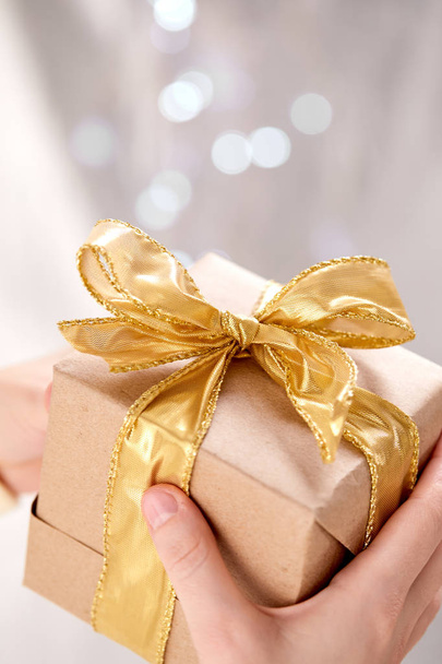 handen houden van ambachtelijke geschenkdoos, close-up - Foto, afbeelding