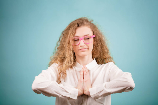 young businesswoman in glasses and white blouse meditating at work - Foto, Imagen