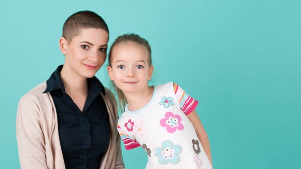 Söpö esikouluikäinen tyttö äitinsä kanssa, nuori syöpäpotilas remissiossa. Syöpä potilaan ja perheen tuki käsite
. - Valokuva, kuva