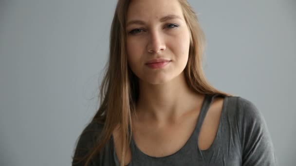 retrato de uma menina loira de aparência europeia em roupas casuais em um fundo cinza
 - Filmagem, Vídeo