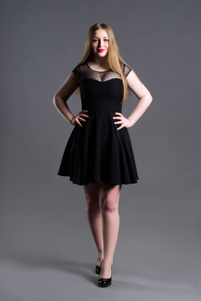 Plus size fashion model in black dress, fat woman on gray studio background, overweight female body - Photo, Image