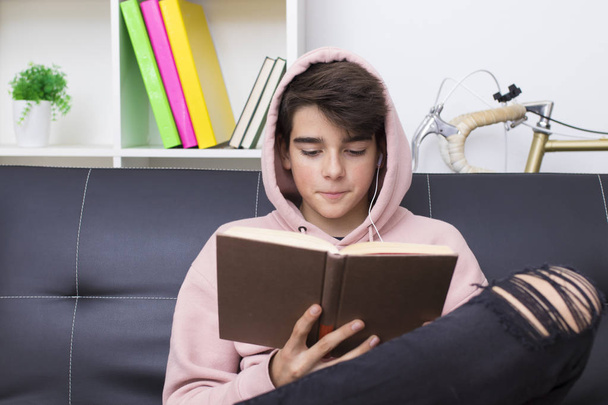adolescente o estudiante preadolescente con el libro de texto en casa
 - Foto, Imagen