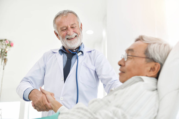 Senior male Doctor is talking with Asian male patient. - Photo, Image