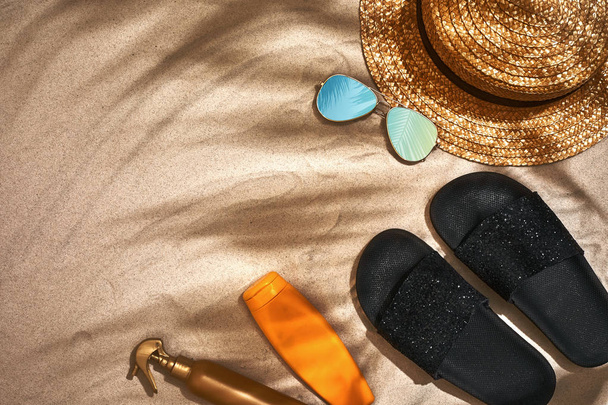 Letní pozadí s slaměný klobouk, sluneční brýle, opalovací krém láhev a žabky - Fotografie, Obrázek