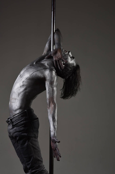 Athlete, flexible sportsman performing pole dancing moves. - Fotó, kép