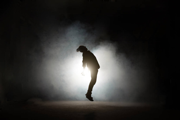 silhouette of young man being gravitated by dark forces - 写真・画像